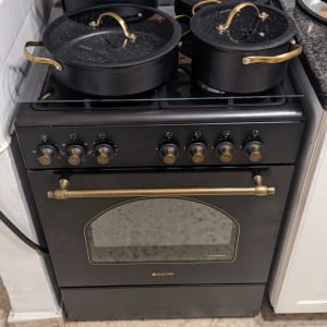 תנור גז שחור עם סירים שחורים ומכסים שקופים