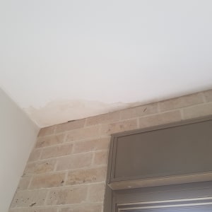 תקרה עם סימני רטיבות מעל קיר לבנים