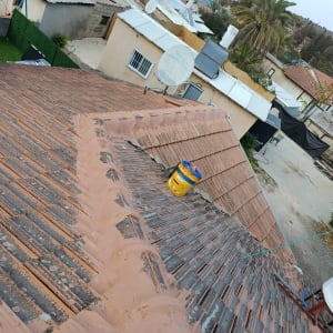 תמונה של גג עם רעפים ועבודת תיקון