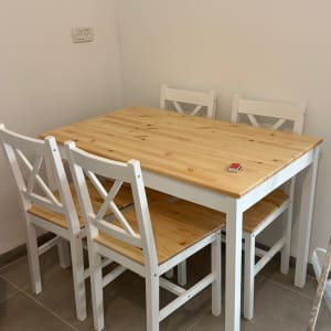 שולחן וכיסאות עץ עם מטאטא בפינה