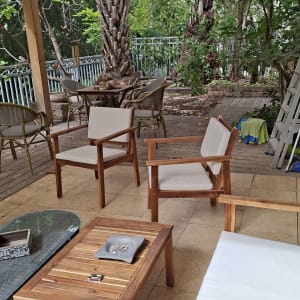 פינת ישיבה מעץ עם עצים וצמחייה ברקע