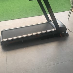 הליכון כושר שחור עם מסך בחצר