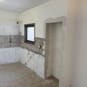 קיר ותקרה בתהליך שיפוץ עם אריחים חשופים