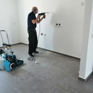 חשמלאי קודח בקיר עם מקדחה חשמלית