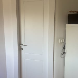 דלת לבנה עם ידית כסופה בחדר