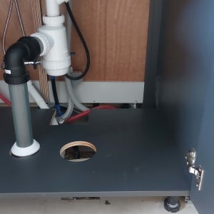 צנרת מתחת לכיור עם חיבורים וצינורות