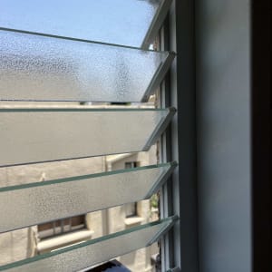 תריסי זכוכית פתוחים עם נוף חיצוני מטושטש