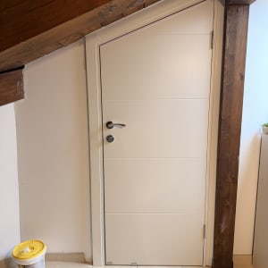 דלת לבנה מתחת לגג עץ משופע