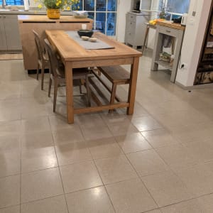 מטבח עם שולחן עץ, כיסאות ופרחים צהובים