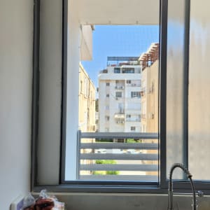 חלון אלומיניום עם מסגרת אפורה במטבח