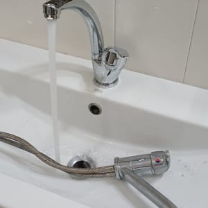 ברז מים זורם בכיור עם צינור גמיש