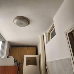 תקרה צבועה בלבן עם מנורה עגולה