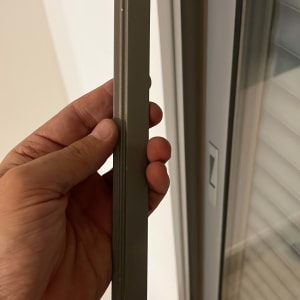 יד מחזיקה חלק מתכת ליד תריס חלון