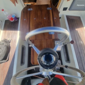 הגה מתכת על רקע עץ בסירה