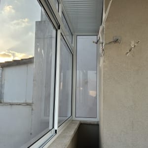 חלונות אלומיניום במרפסת סגורה עם קיר חיצוני