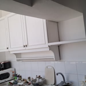 ארונות מטבח לבנים עם מכשירי חשמל על השיש