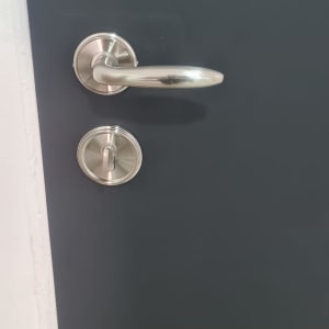 ידית דלת מתכתית על דלת כהה