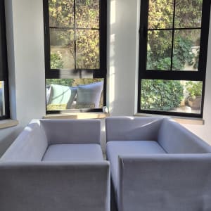ספות אפורות בחדר עם חלונות גדולים