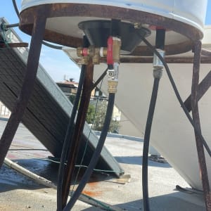 חיבורים וצינורות מתחת לדוד שמש על גג