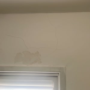 קיר עם סדקים ותיקון טיח מעל חלון