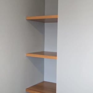 מדפי עץ מותקנים בפינת קיר