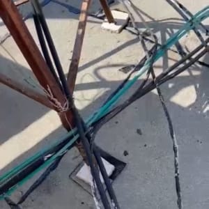 כבלים קשורים למוט מתכת על גג בטון