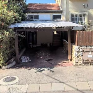 חניה מקורה ליד בית עם גג רעפים