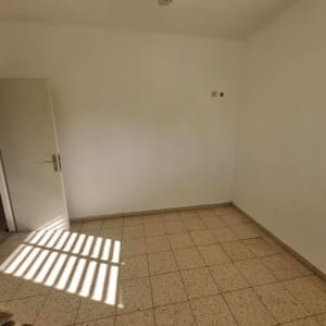 חדר ריק עם רצפת אריחים ודלת פתוחה