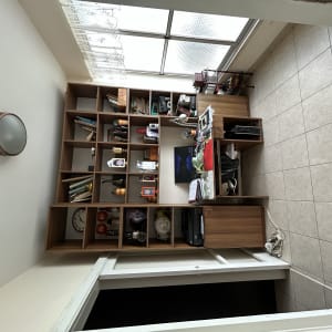 חדר עם מדפים, שולחן ומנורה על הקיר