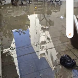 שלולית גדולה על המדרכה עם השתקפות בניין