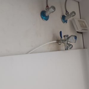 ברזים וצינורות מתכת על קיר לבן