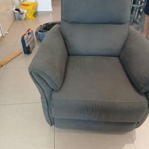 כורסה אפורה עם כלי עבודה ברקע