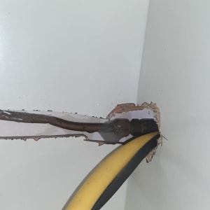 צינור גז צהוב ושחור יוצא מקיר לבן