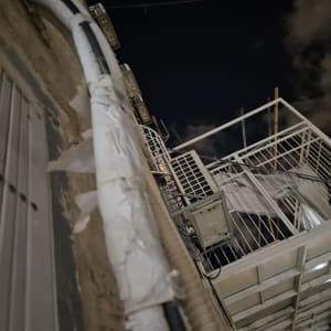 צינור מיזוג אוויר עטוף בבידוד על קיר חיצוני