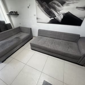 שתי ספות אפורות בחדר עם רצפת קרמיקה