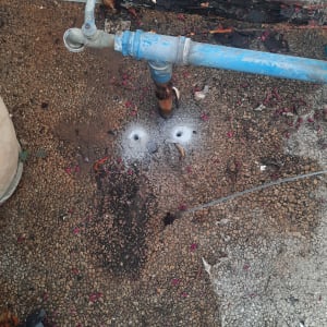 צינור מים כחול עם ברז על רצפה רטובה