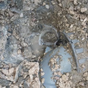 צינור דולף באדמה עם מים מסביב