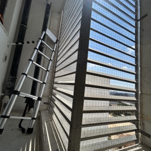 סולם ליד רשת על חלון במבנה גבוה