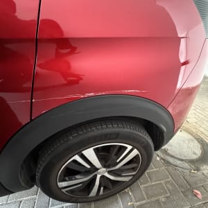 רכב אדום עם שריטה על הכנף האחורית