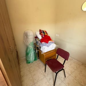 חדר עם כיסא, ארון ובגדים על שולחן