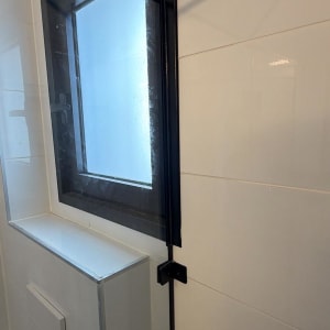חלון זכוכית במקלחת עם מסגרת שחורה