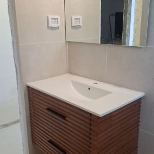 כיור אמבטיה עם ארון ומראה בחדר שיפוצים