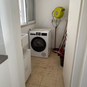 חדר כביסה עם מכונת כביסה וכלי ניקוי