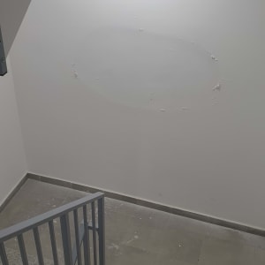 קיר עם קילופי צבע באזור מדרגות