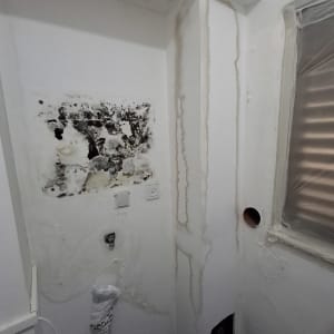קיר עם סימני רטיבות ותיקונים בצבע