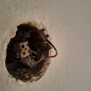 חוטי חשמל חשופים בקיר עם חיבורים ישנים