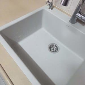 כיור מטבח מותקן בהתקנה שטוחה במשטח שיש בגוון בז
