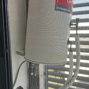 דוד שמש מותקן על קיר עם צינורות וחיבורים