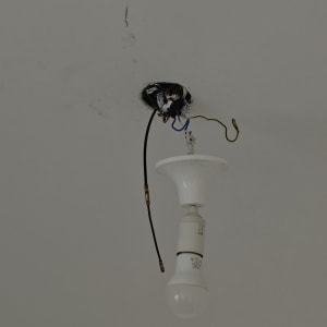 חוטי חשמל חשופים ונורה תלויה מהתקרה