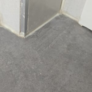 תקריב של ריצוף אריחי גרניט פורצלן אפורים בפינת חדר